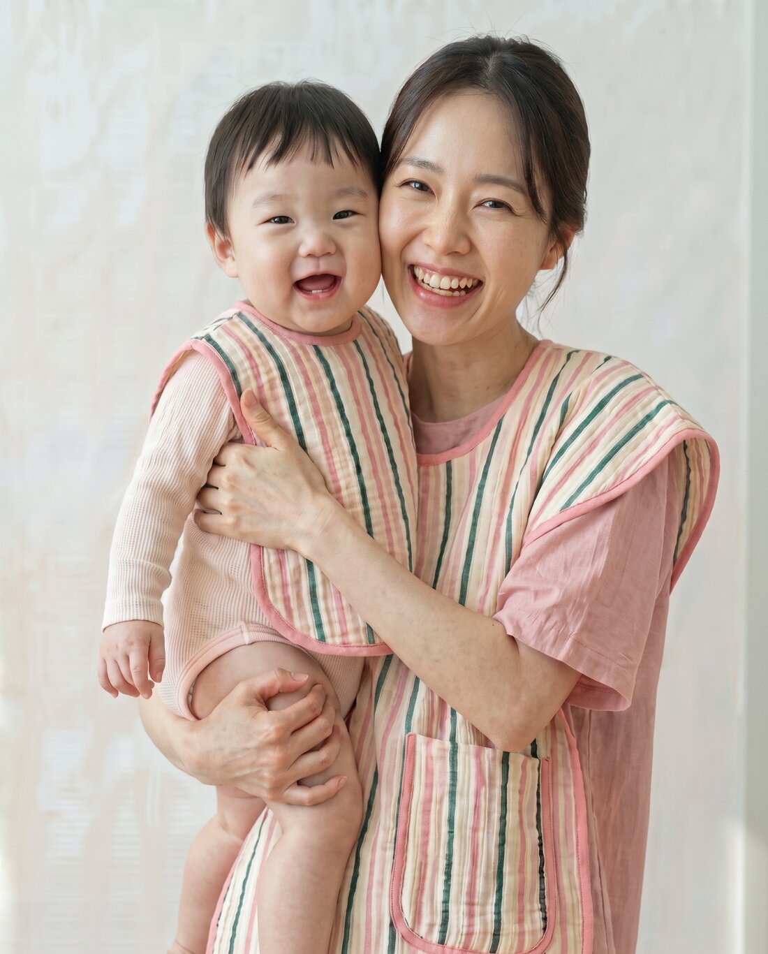 버니데이 포숑 앞치마를 두르고 아기를 안은 보호자